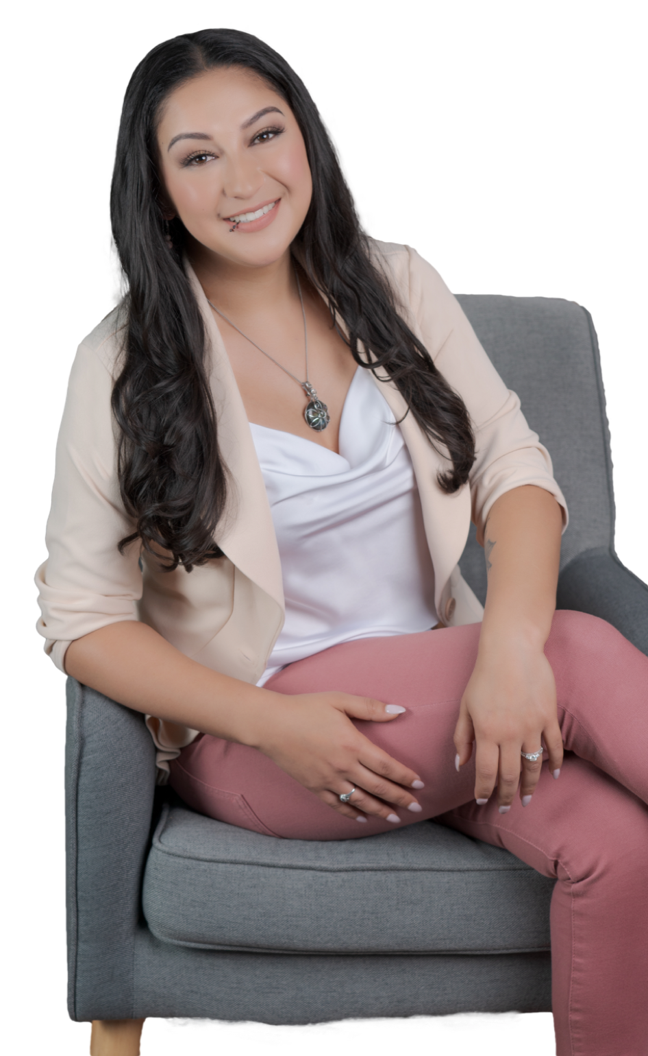 Crystal Venegas, LMFT sitting on a chair with her legs crossed.