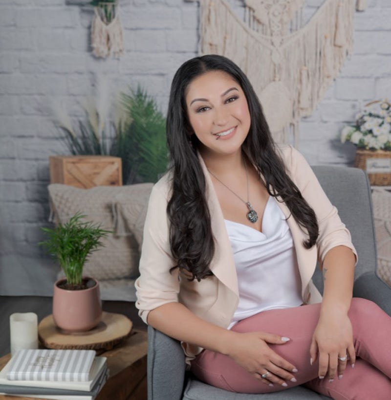 Crystal Venegas, LMFT sitting on a chair.