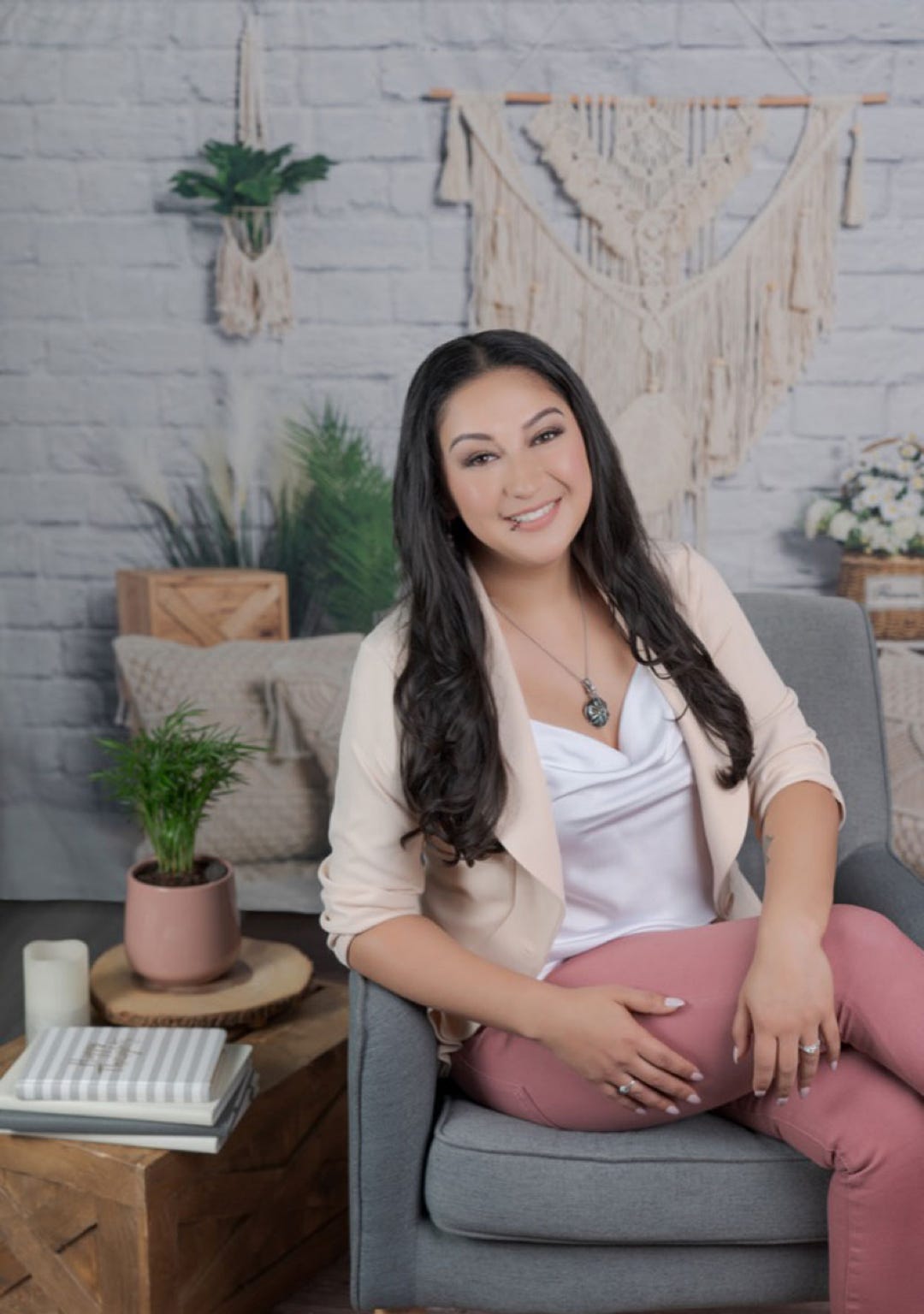 Crystal Venegas, LMFT sitting on a chair.