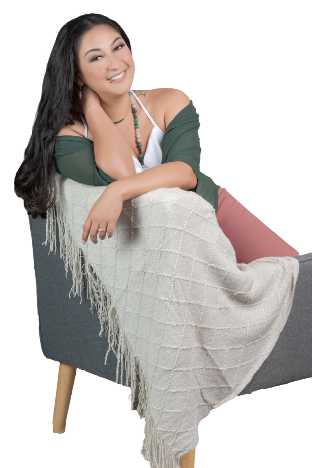 Crystal Venegas, LMFT sitting on a chair with a white blanket on it. 
